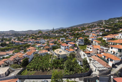High angle view of houses in town against clear sky