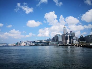 Buildings in city against cloudy sky