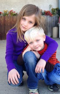 Portrait of happy mother and daughter sitting on floor