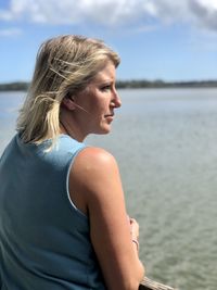 Young woman looking at sea shore against sky