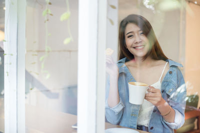 Portrait of young woman drinking coffee