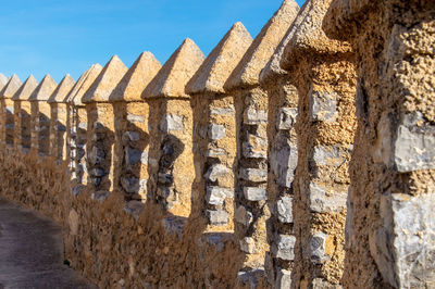 Low angle view of old wall against sky