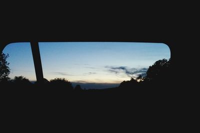 Silhouette trees against sky at sunset