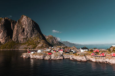 People on rock by sea against sky