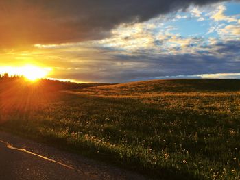 Scenic view of field against sky at sunset