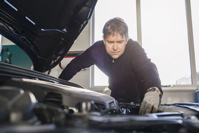 Mechanic repairing car engine in auto repair shop