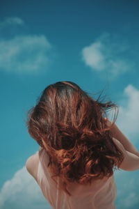 Low angle view of woman standing against sky