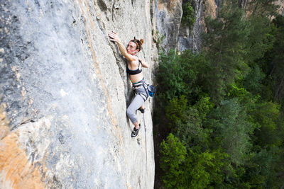 High angle view of woman climbing rock