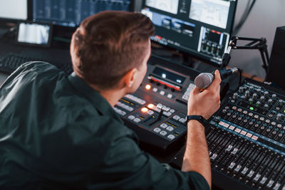 Setting the equipment. young man is indoors in the radio studio is busy by broadcast.