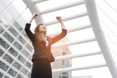 Businesswoman standing against building