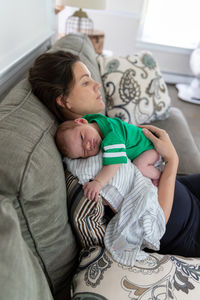 Mother holding her newborn baby on her shoulder.