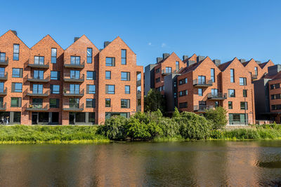 Residential buildings by the river against the sky