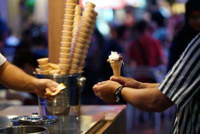 Midsection of people holding ice cream