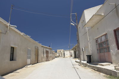 Street amidst buildings against clear sky