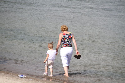 Rear view of women standing on beach