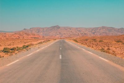 Empty road on desert against clear sky