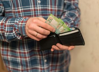 Midsection of man removing paper currencies from wallet