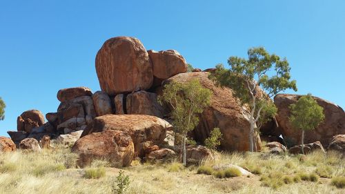 Low angle view of rock formation against clear blue sky