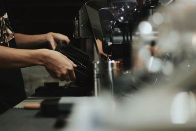 Cropped image of barista making coffee in cafe