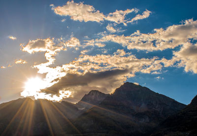 Sunlight streaming through clouds over landscape