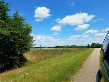 Scenic view of grassy field against cloudy sky