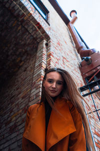 Portrait of woman standing against wall