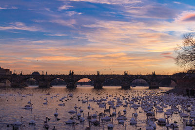 Bridge over river against sky during sunset