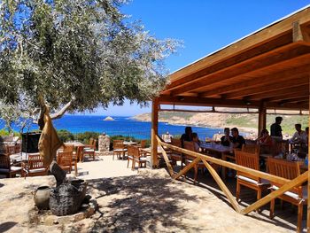 Chairs and tables at restaurant against clear sky