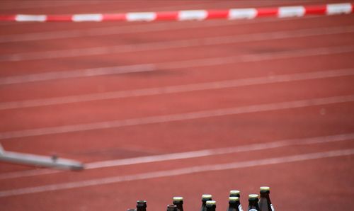 Full frame shot of bottles against running track 