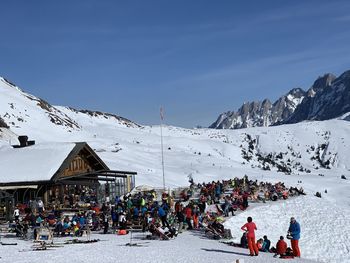 People on snowcapped mountains against sky