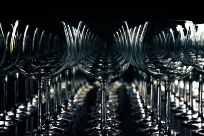 Close-up of wineglasses arranged on table against black background