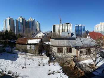 Houses in city against clear sky during winter