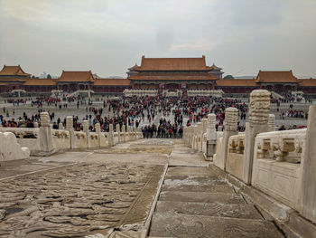 Group of people outside temple against sky