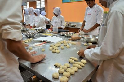 People working on table in kitchen