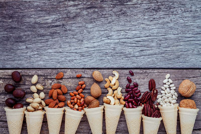 High angle view of ice cream cones with nuts on wooden table