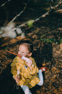 Cute girl holding plant on land