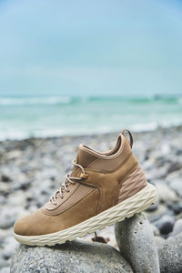 Close-up of shoes on beach