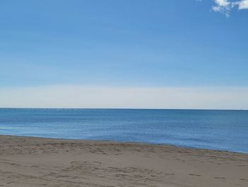 Scenic view of beach against clear blue sky