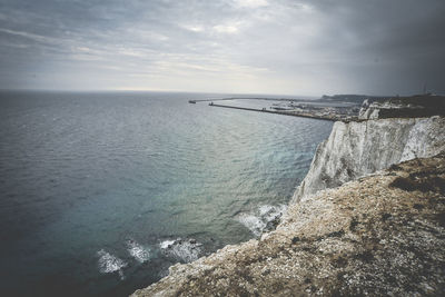 Scenic view of mountain by sea against sky