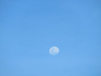 Low angle view of moon against blue sky