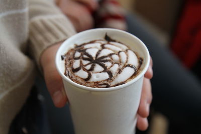 Close-up of hand holding cappuccino