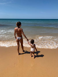 Full length of friends on beach against sea