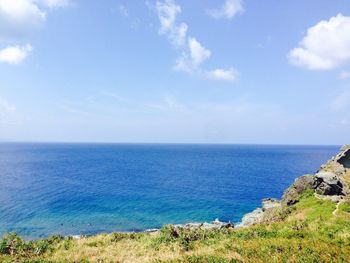 Scenic view of calm sea against cloudy sky