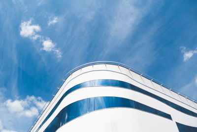 Low angle view of modern building against cloudy sky