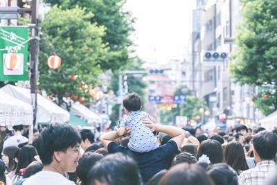 Rear view of people walking on city street