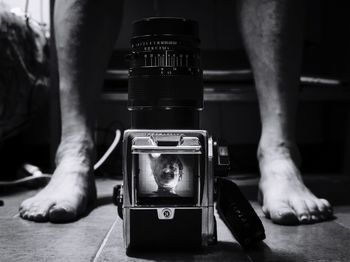 Low section of man by digital camera on floor at home