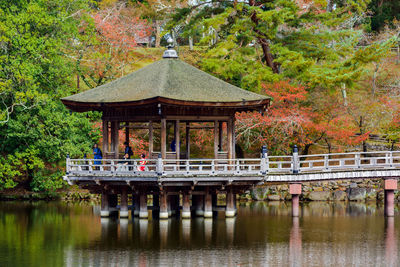 Footbridge over lake against trees during autumn