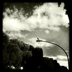 Low angle view of airplane flying against cloudy sky