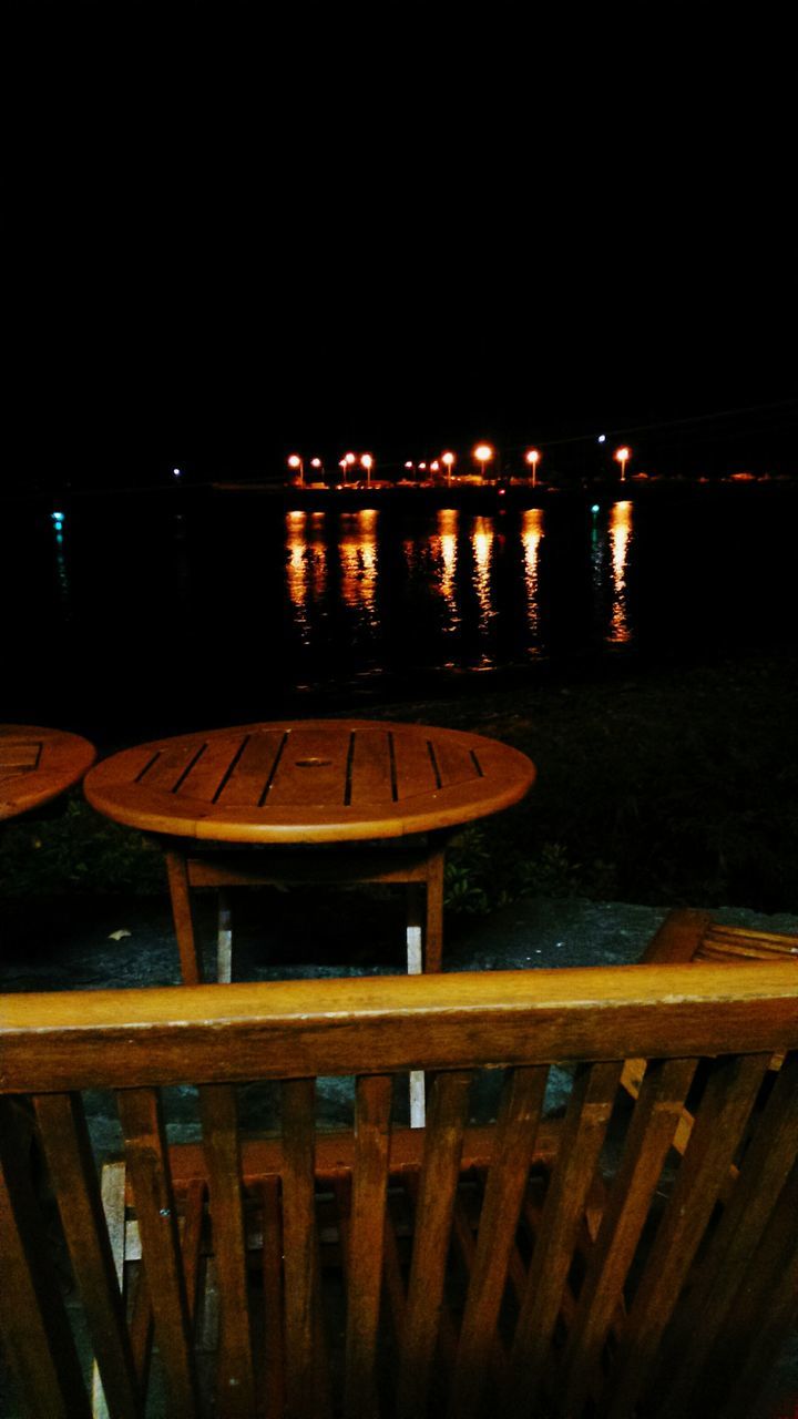 night, illuminated, water, railing, pier, reflection, sea, wood - material, tranquility, clear sky, copy space, dark, tranquil scene, built structure, high angle view, no people, empty, river, in a row, nature