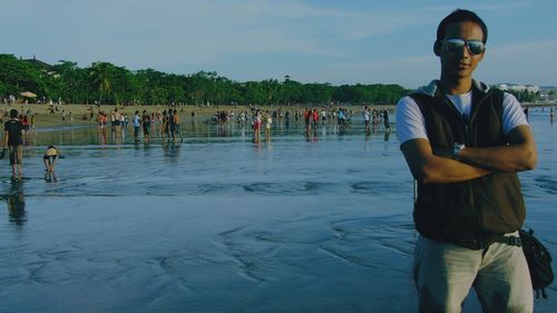 People standing on shore against sky